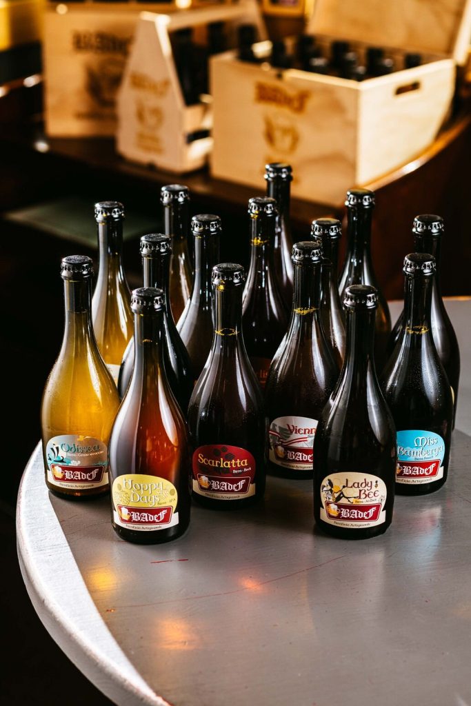 Bottiglie di birra artigianale Badef allineate sul tavolo d'acciaio del birrificio