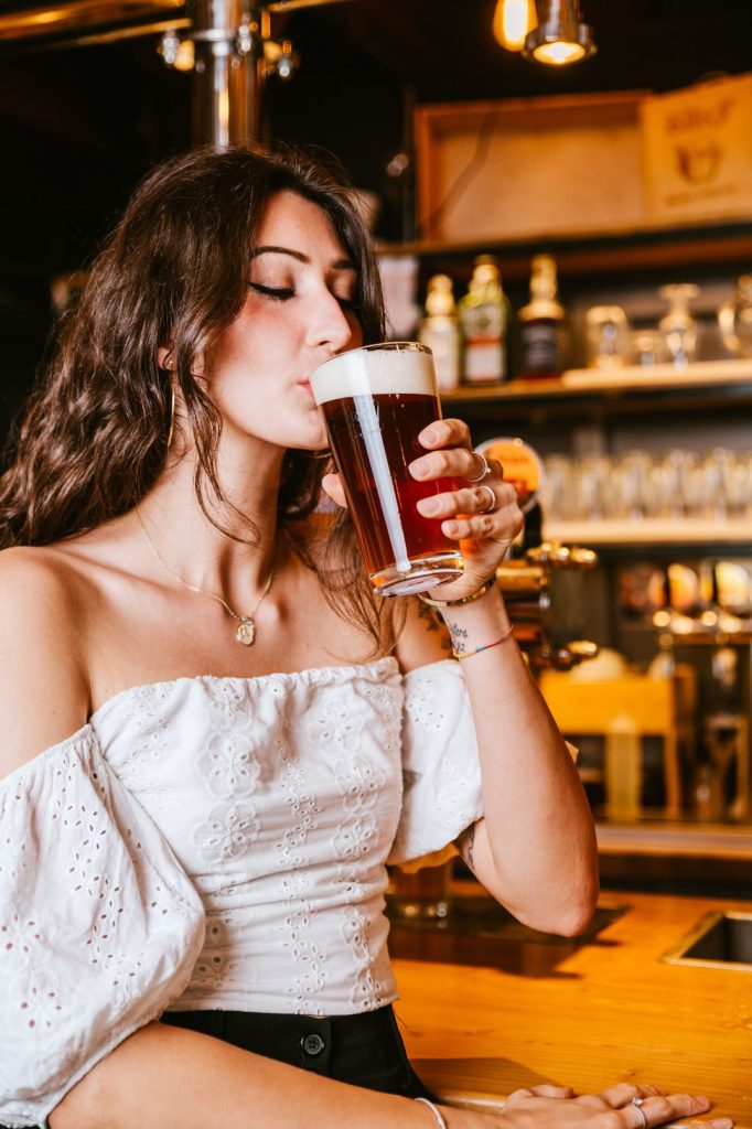 Una cliente beve una birra Badef seduta al bancone del Brew Pub