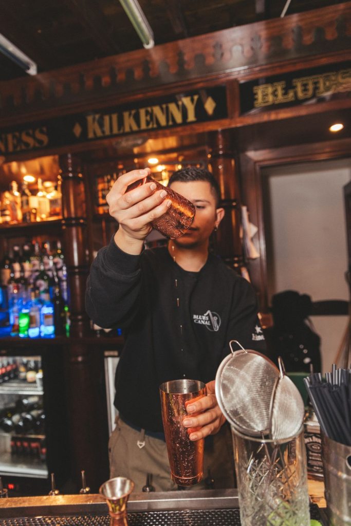 Il barista prepara un drink dietro al bancone