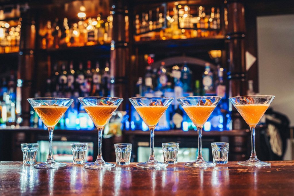 Cinque cocktail in fila sul bancone del locale