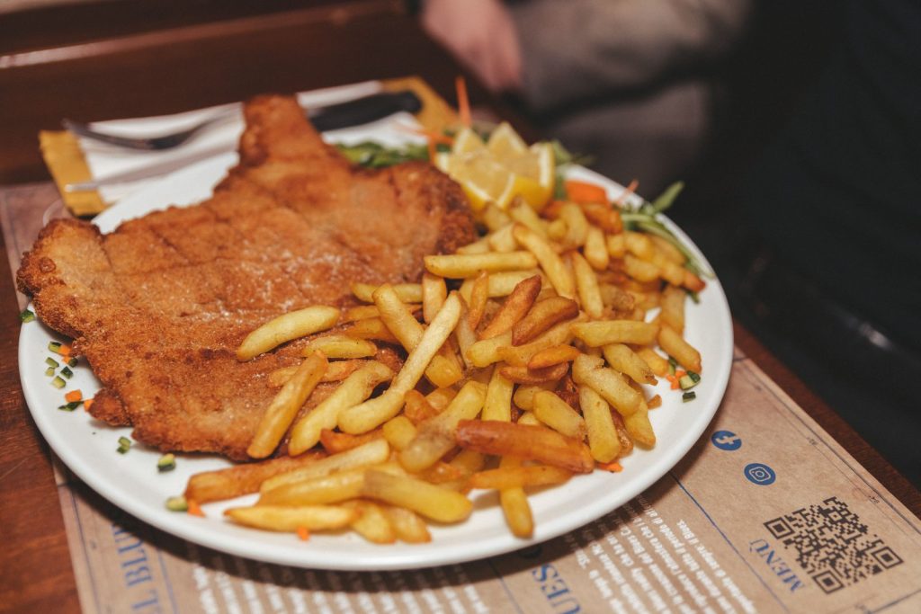 Cotoletta con patatine fritte servita al tavolo