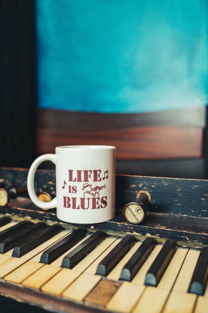La tazza Life is Blues appoggiata sui tasti del pianoforte