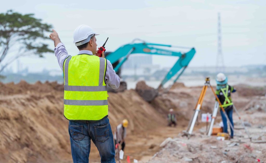 Operaio Bonzi S.p.A. in cantiere accanto all'escavatore