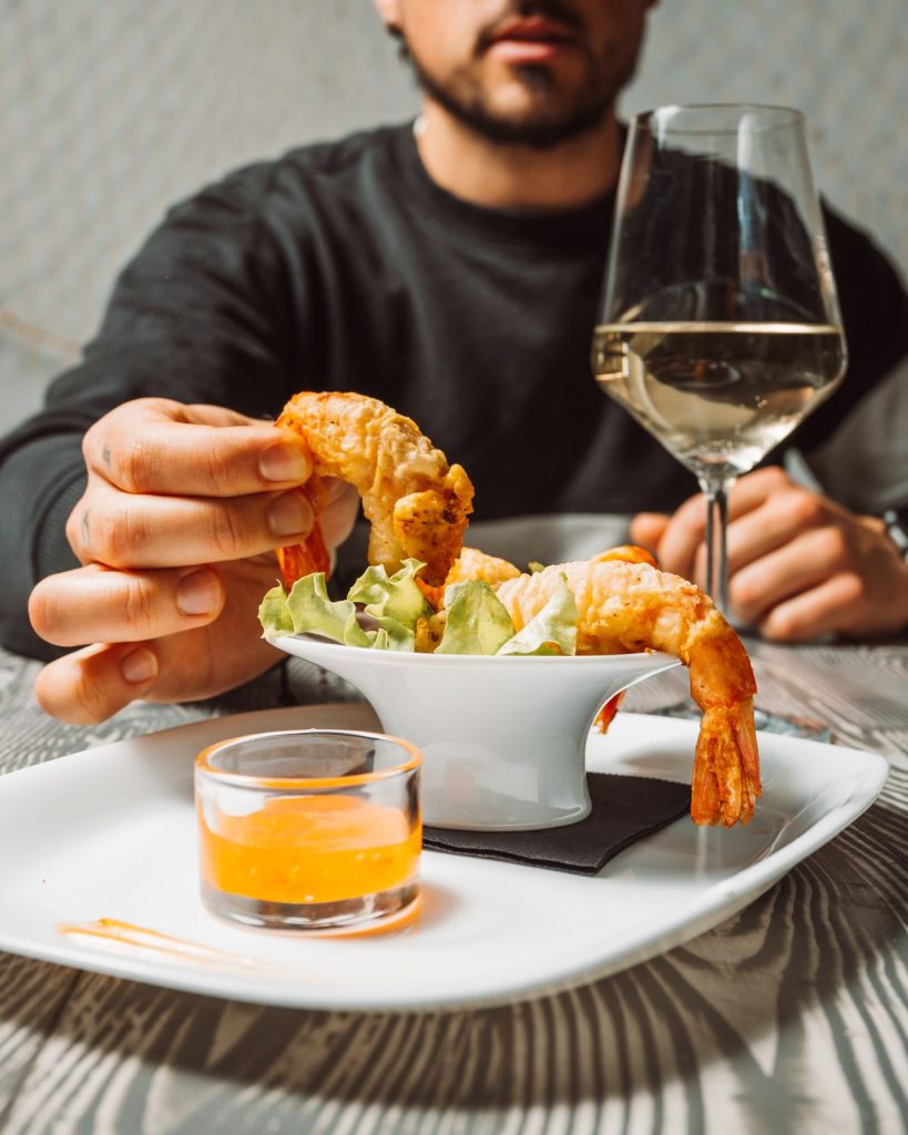 Un cliente prende un gambero dallantipasto