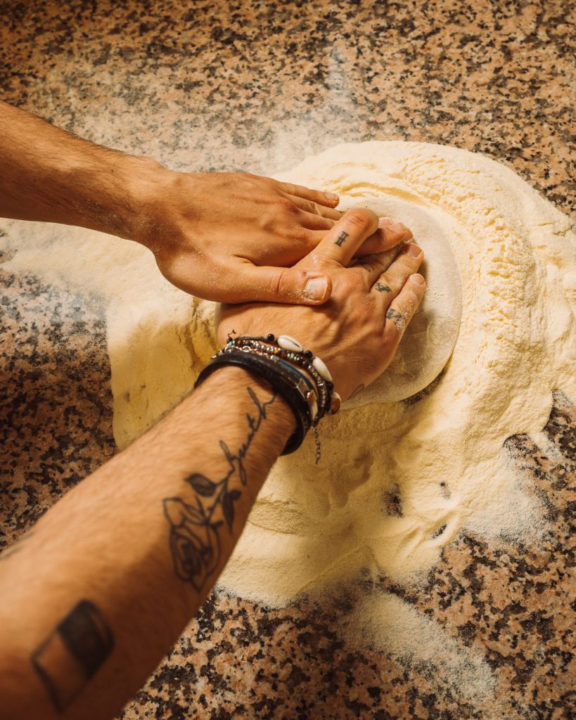 Le mani del pizzaiolo che lavorano limpasto