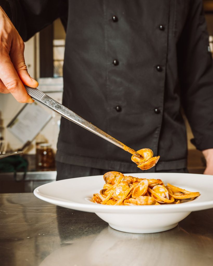 Lo chef impiatta la pasta in cucina