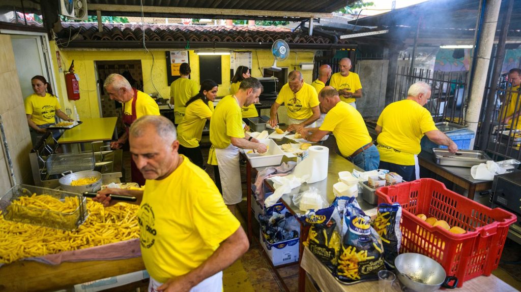 I volontari in maglia gialla al lavoro nella cucina della festa
