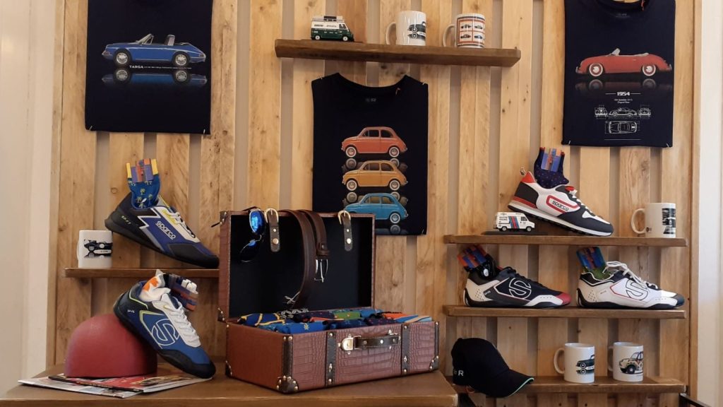 Espositore con calzature e oggetti a tema motori nel negozio FuoriGiri Fashion
