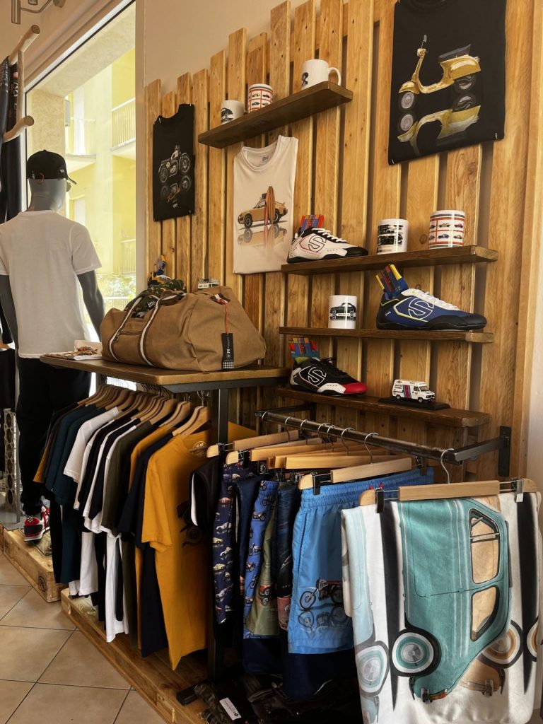 Scaffali in legno con abbigliamento e calzature nel negozio FuoriGiri Fashion
