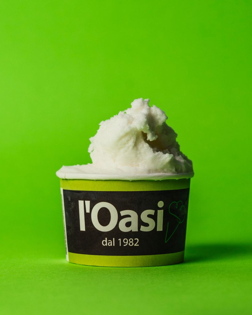 Coppetta di gelato al fiordilatte fotografata su fondo verde