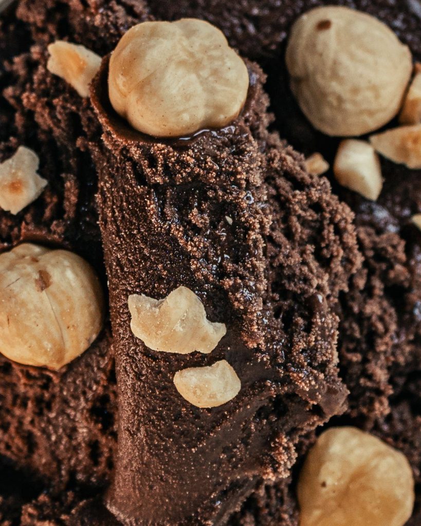 Primo piano del gelato al cioccolato con le nocciole intere in superficie