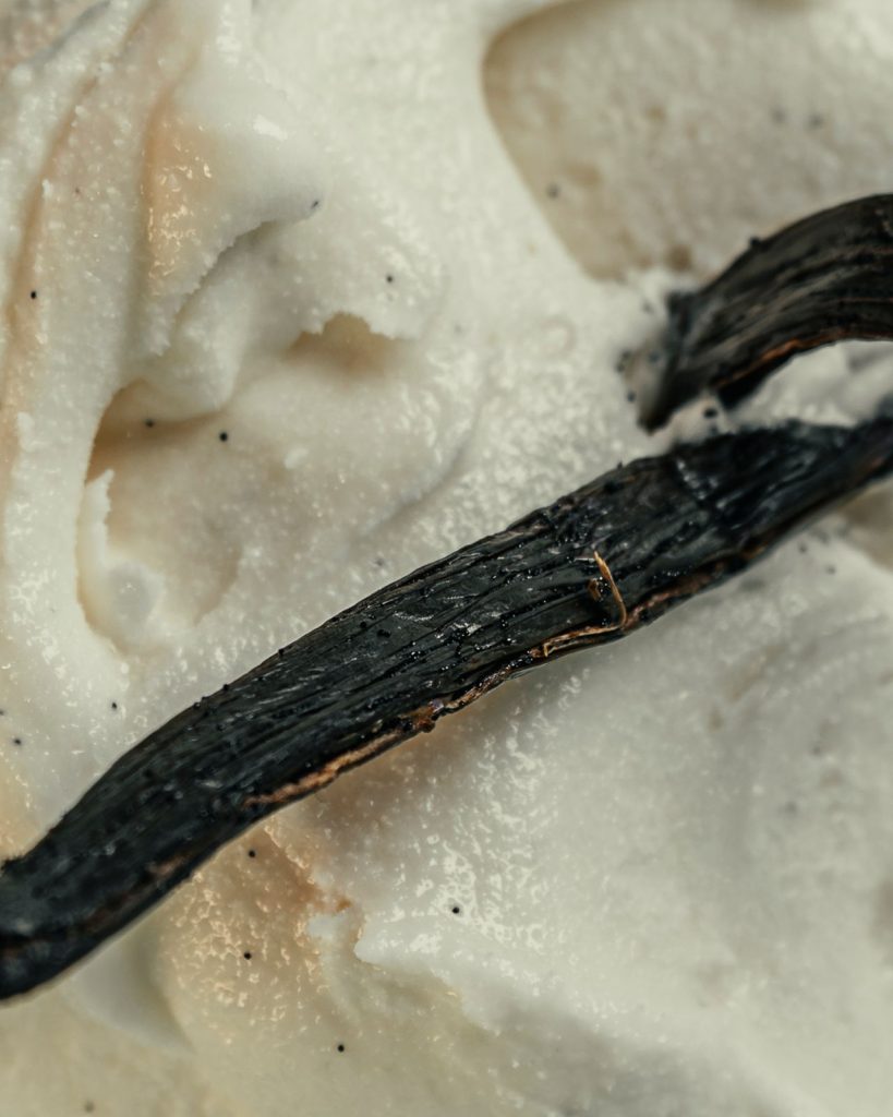 Primo piano del gelato alla vaniglia con la bacca appoggiata sopra