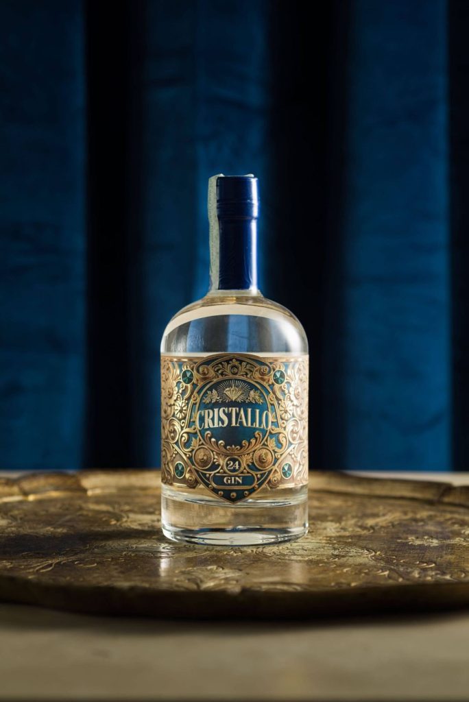 Bottiglia di Gin Cristallo in primo piano su fondo blu