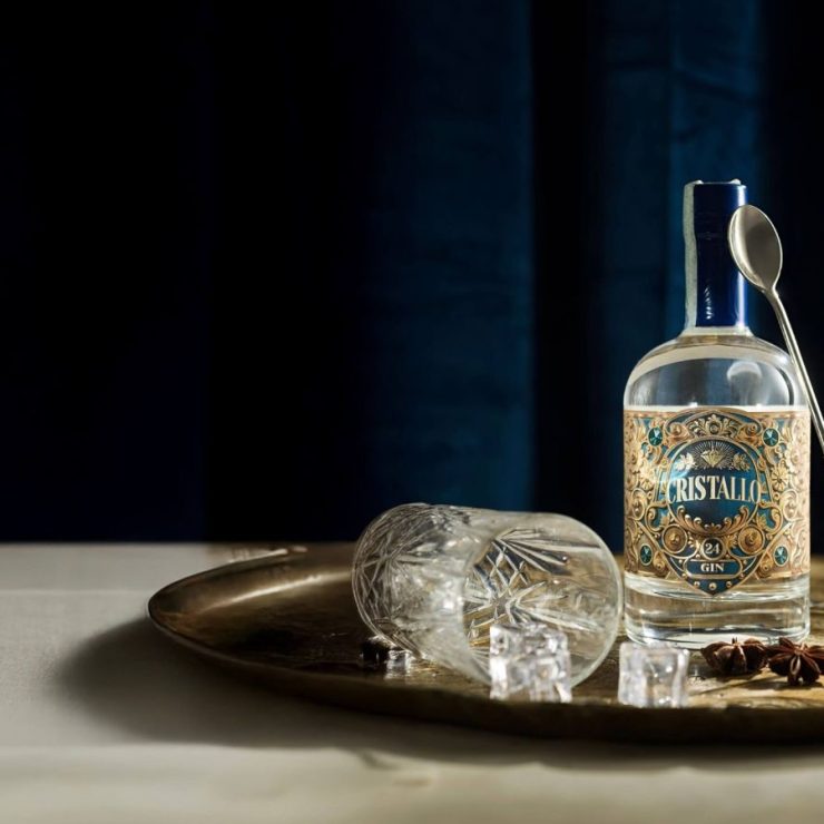 Bottiglia di Gin Cristallo su un vassoio di rame, con ghiaccio e agrumi