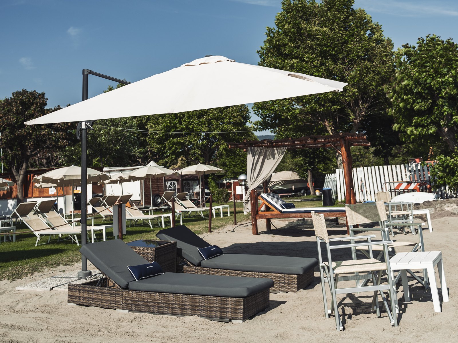 La spiaggia del Lido di Iseo con lettini, ombrellone e baldacchino sulla sabbia