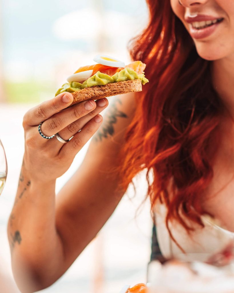 Ospite del Lido Iseo con un club sandwich al tavolo in riva al lago