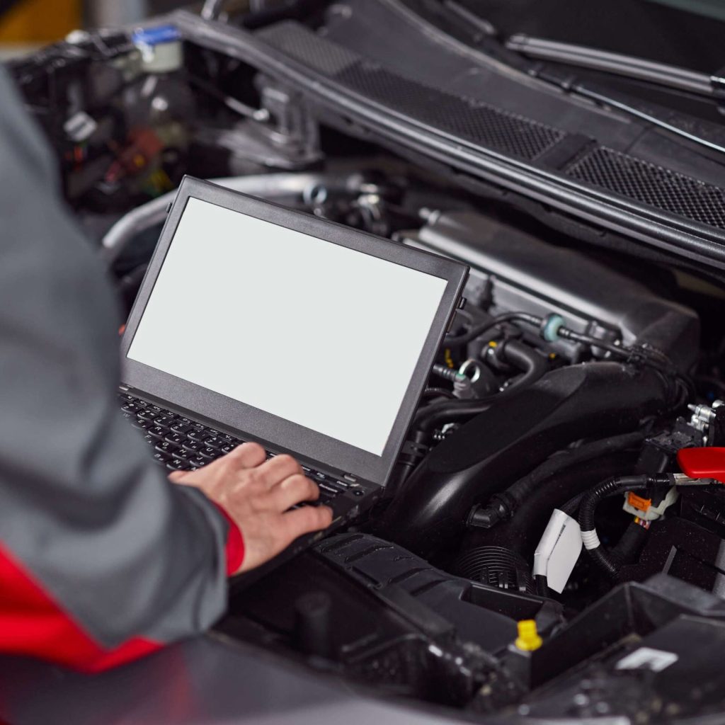 Tecnico con lo strumento di diagnostica elettronica collegato alla centralina dell'auto