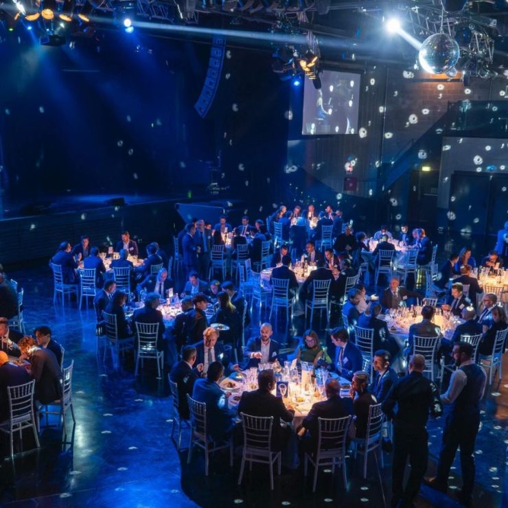 La sala della serata di gala Newsteca vista dall'alto, con i tavoli illuminati di blu