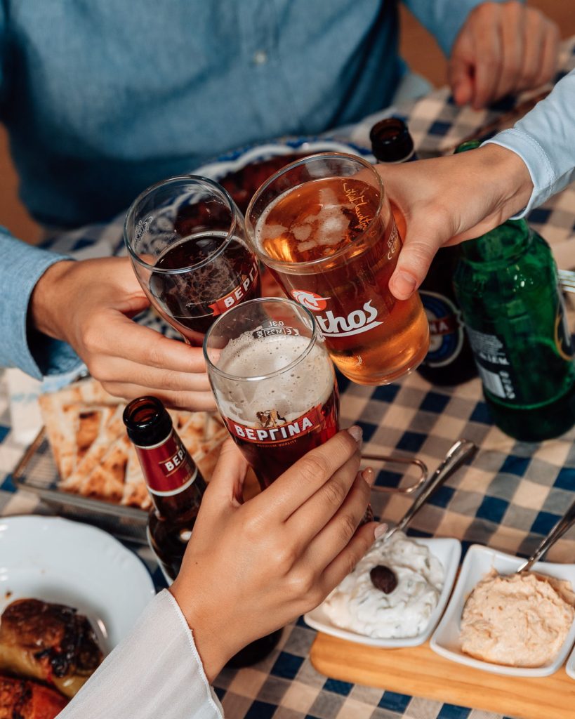 Brindisi con birre greche tra amici a tavola