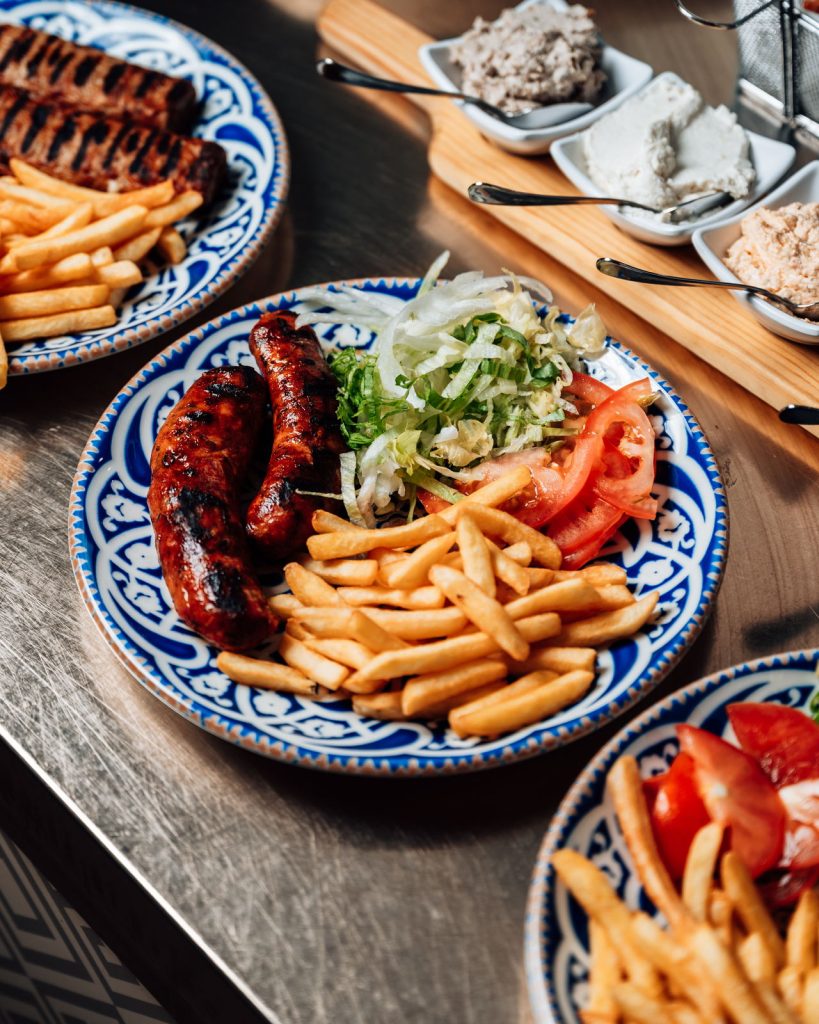 Piatto di gyros e spiedini con patatine e salsa tzatziki