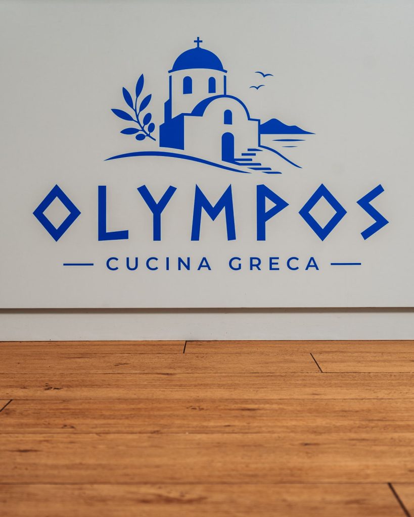 Logo Olympos Cucina Greca sulla parete del ristorante
