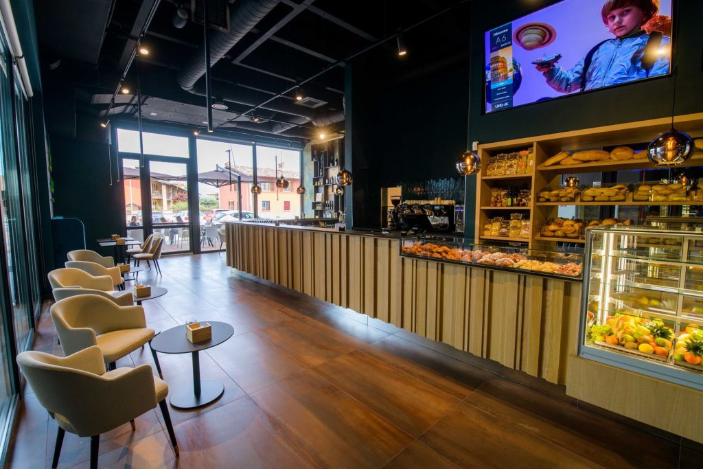 Il bancone del bar con la vetrina dei dolci e la sala sullo sfondo