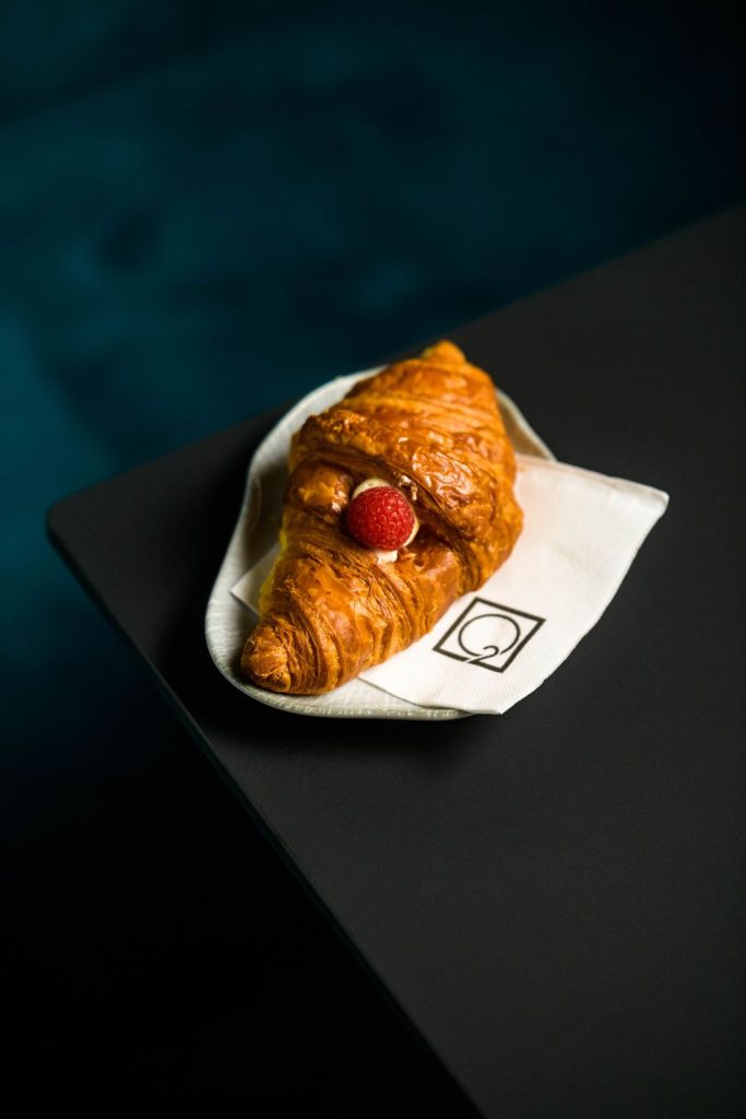 Un croissant servito sul tovagliolo con il logo del locale