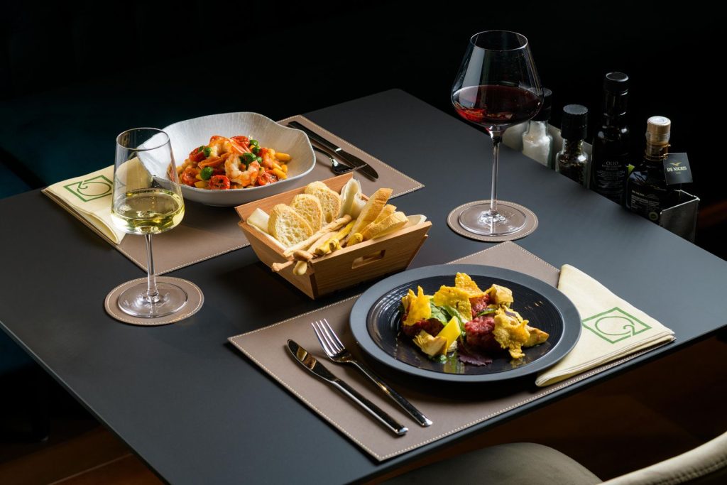 Tavola apparecchiata per il pranzo con due piatti e i calici di vino