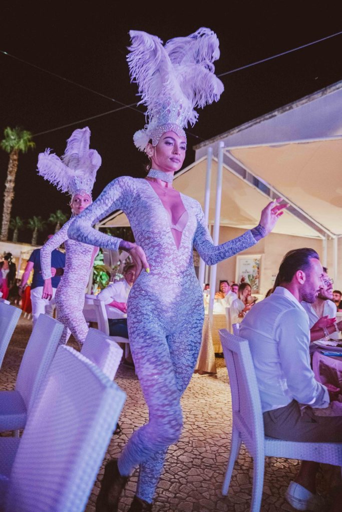 Una performer in costume bianco tra i tavoli