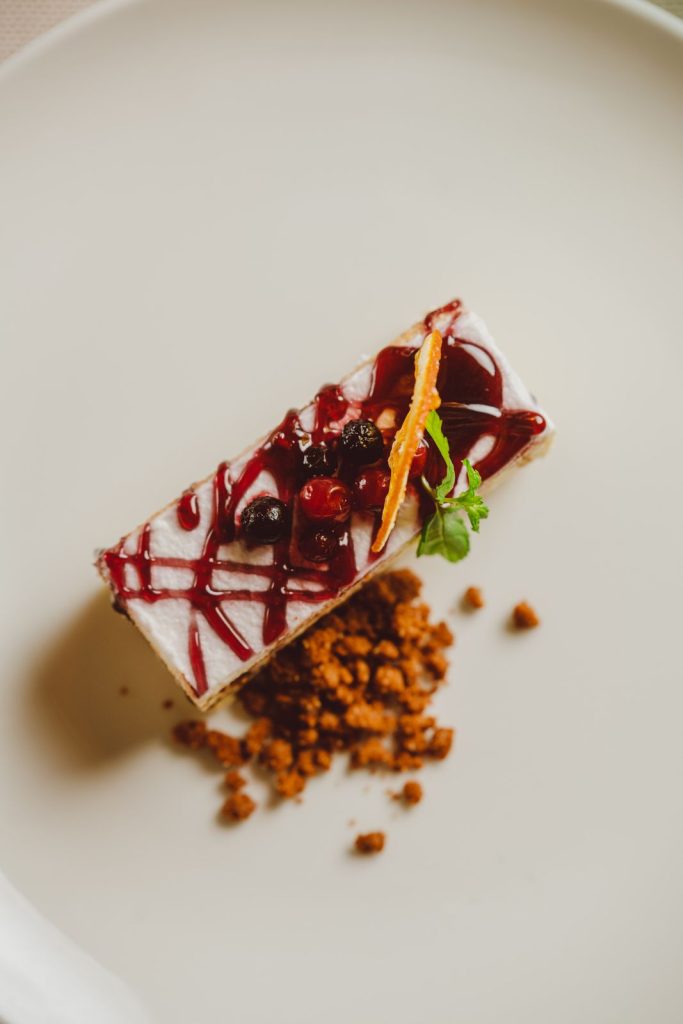 Un dolce impiattato con la salsa ai frutti rossi