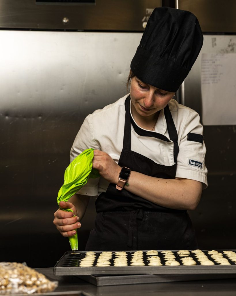 Pasticcere della Pasticceria Serlini che dosa i biscotti con la sac à poche