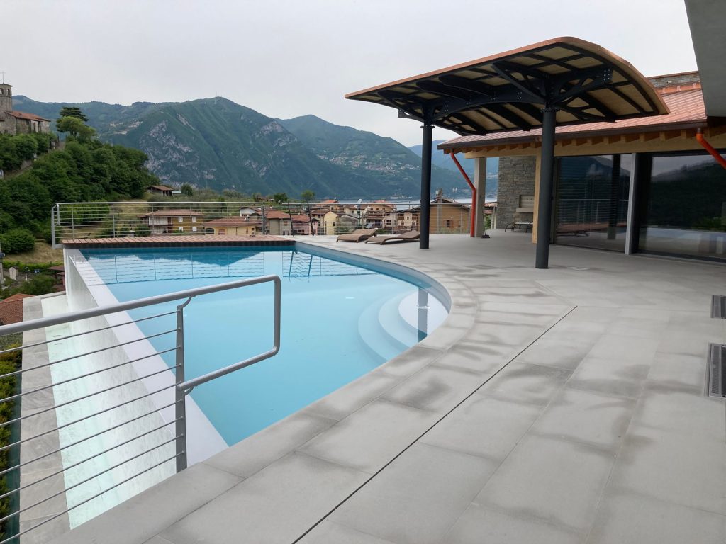 Una tettoia in acciaio a bordo piscina con vista sulle montagne