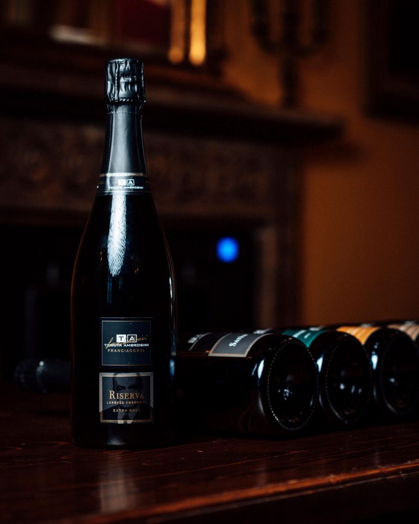 Bottiglia di Franciacorta Tenuta Ambrosini sul bancone della cantina