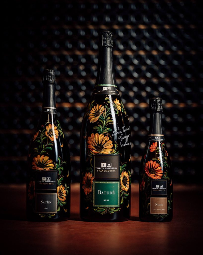 Tre bottiglie di Franciacorta Tenuta Ambrosini con le etichette floreali