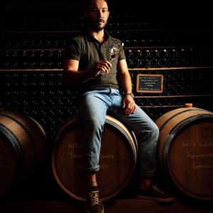 Ritratto in cantina seduto sulle botti di Tenuta Ambrosini