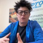 Tina Alogna parla in camera davanti al roll-up di TipTop Italia