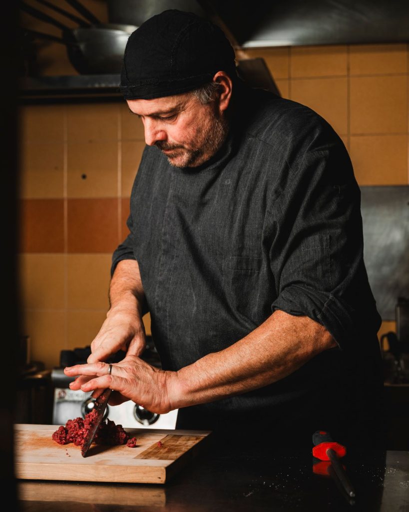 Lo chef del Ristorante La Torre taglia al coltello la carne per la tartare