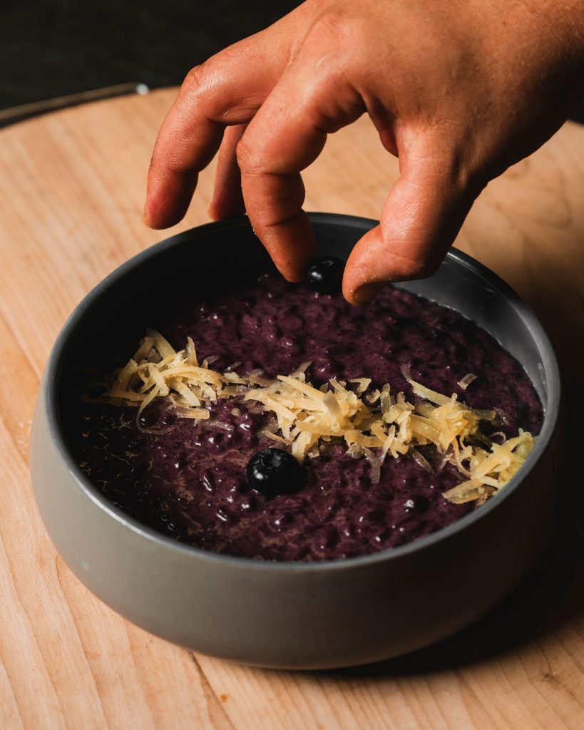 Lo chef completa il risotto con Bitto e mirtilli del Ristorante La Torre di Zogno