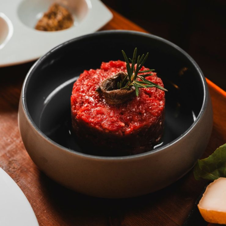 Tartare di manzo con rosmarino servita in una ciotola scura, Ristorante La Torre di Zogno